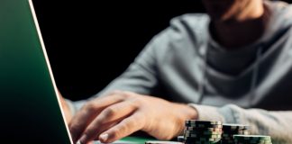 Man using laptop with casino chips