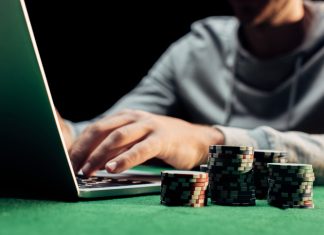 Man using laptop with casino chips