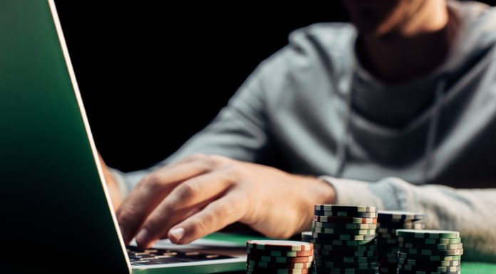 Man using laptop with casino chips