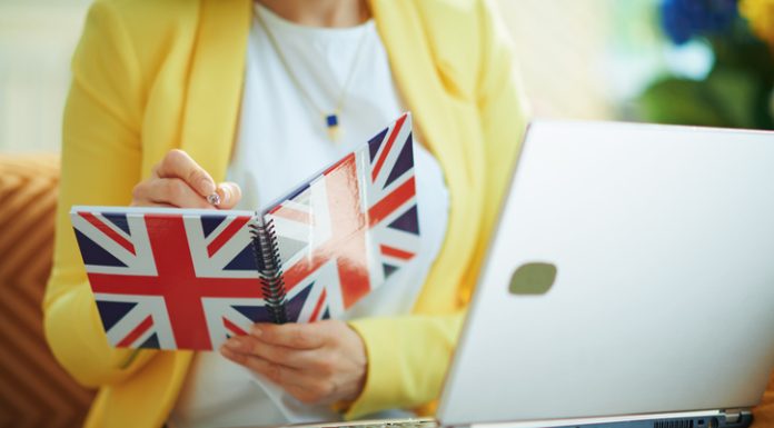 Female taking down notes in a UK flag notebook