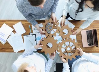 Employees in office connect gears in place. Business team building concept