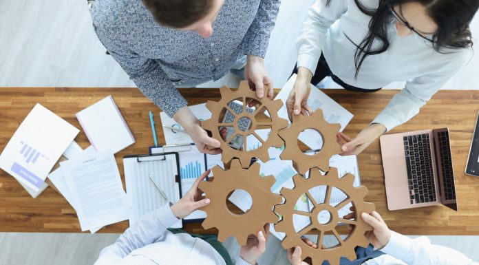 Employees in office connect gears in place. Business team building concept