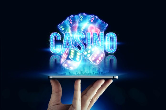 In a man's hand a smartphone with playing cards roulette and chips, black-neon background. Concept of online gambling, online casino. Copy space.3D illustration, 3D render Online Casino