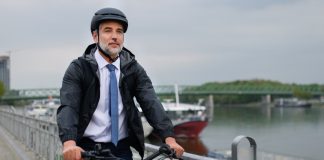 A businessman commuter on the way to work, riding bike in city, sustainable lifestyle concept.