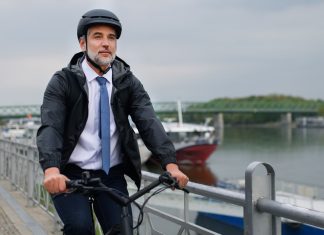 A businessman commuter on the way to work, riding bike in city, sustainable lifestyle concept.