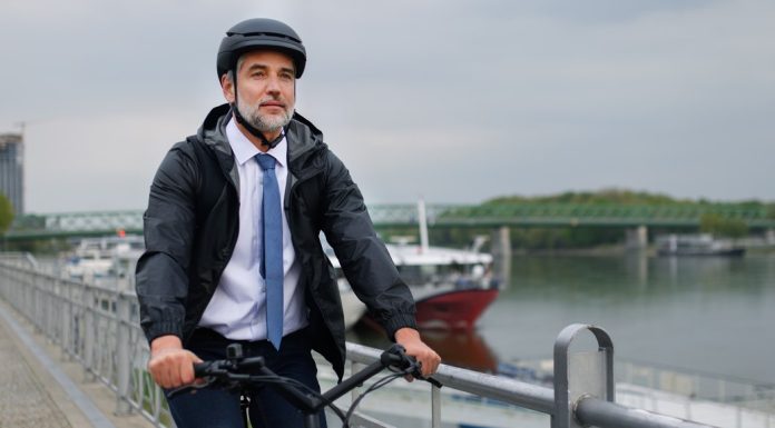 A businessman commuter on the way to work, riding bike in city, sustainable lifestyle concept.