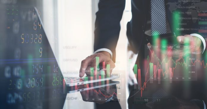 Businessman working with stock market investment, using laptop computer analyzing trading data with stock exchange graph on screen. Financial stock market trade, currency exchange. Data Analytics