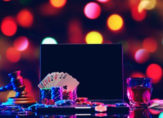 Gavel, playing cards and chips on computer