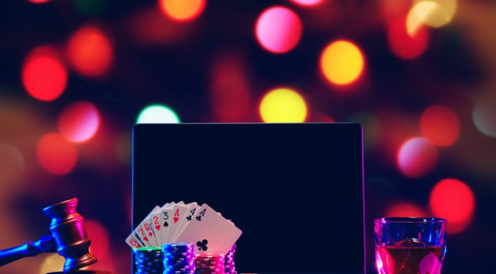 Gavel, playing cards and chips on computer