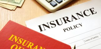 Insurance quotes book and policy on a desk.