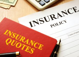 Insurance quotes book and policy on a desk.