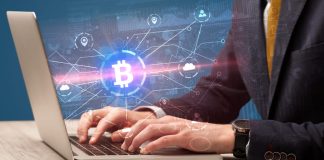 Businessman using laptop with bitcoin symbol