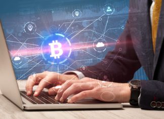 Businessman using laptop with bitcoin symbol