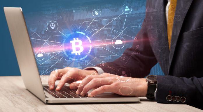 Businessman using laptop with bitcoin symbol