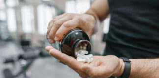 Navigating Natural Muscle Enhancers: How to Choose a Safe Alternative to Steroids Sporty muscular man arms showing sports and fitness supplements