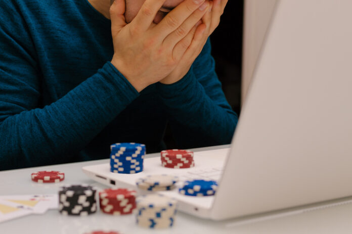 young man playing with his computer on gambling websites. online casino poker roulette. Lifestyle. Winner or bankrupt by becoming a millionaire. Man playing with his computer on gambling websites