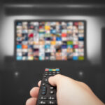 Top Features to Look for in an IPTV Subscription Hand holding remote control for TV