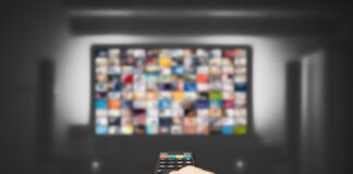 Top Features to Look for in an IPTV Subscription Hand holding remote control for TV