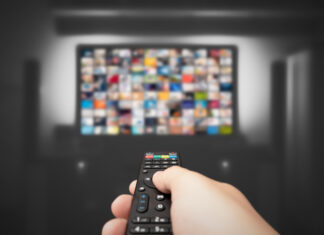 Hand holding remote control for TV
