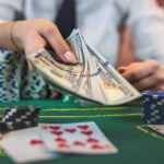 Get Your Winnings Faster: Tips to Speed Up Online Casino Payouts Female player counts chips for money and raises during poker game in casino.