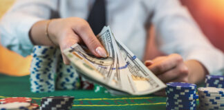 Female player counts chips for money and raises during poker game in casino.