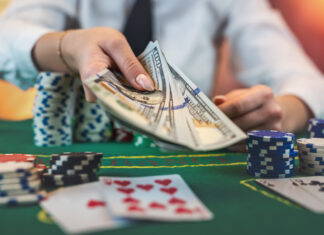 Female player counts chips for money and raises during poker game in casino.