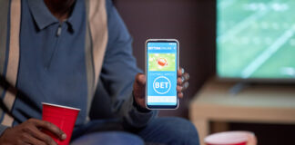 Online Betting in Botswana Close up of man holding smartphone with sports bets app