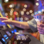 The Best Time to Hit the Slots: Myth or Reality? Female Gambler Hand hold money bill ready to win the game with one best shot casino