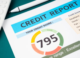 Credit score report and calculator on the desk.