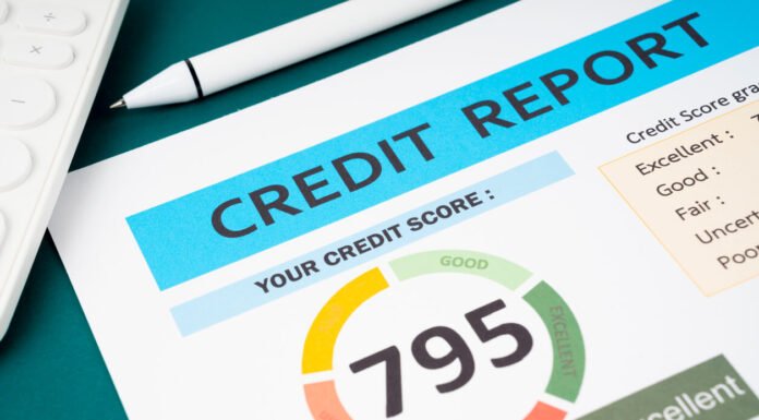 Credit score report and calculator on the desk.