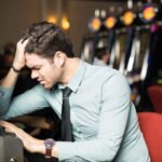 Psychology at Play: Understanding the Gambler’s Mindset for Better Outcomes Man losing money in a casino
