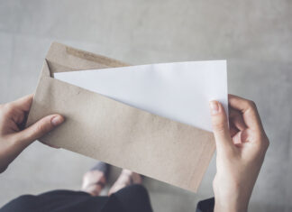 woman holding white folded a4 paper and brown envelope