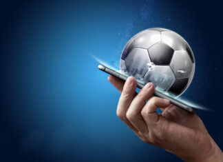 Smartphone in hand with a 3D soccer ball on a blue background