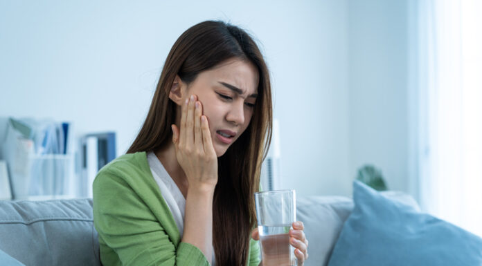 Asian beautiful woman feel terrible toothache after drink cold water.