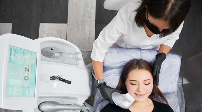 Female skill-advanced doctor holding modern medical equipment for non-surgical face lifting