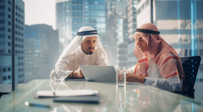 Two Successful Emirati Businessmen in White Traditional Kandura Sitting in Office Meeting