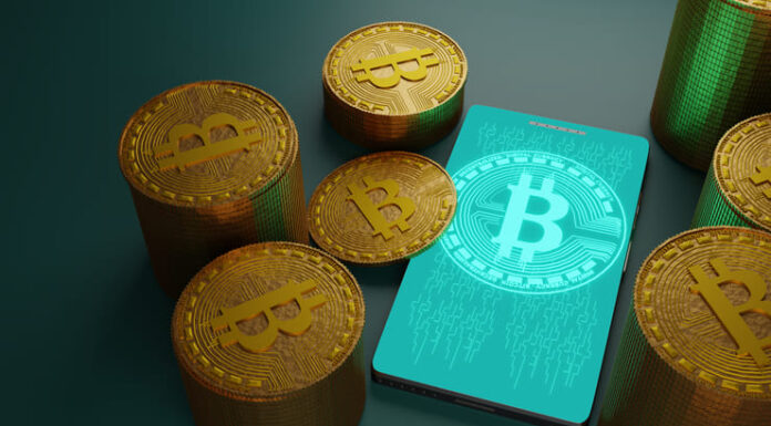 Bitcoin cryptocurrency with pile of coins and smartphone