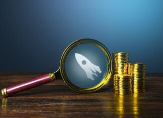 Running Out of Road: Why Tech Firms Need to Fast-Track their Pathway to Profitability Coins stack with magnifying glass for start up