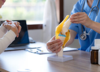 Female doctor who is explaining the treatment method of the knee joint to the woman patient