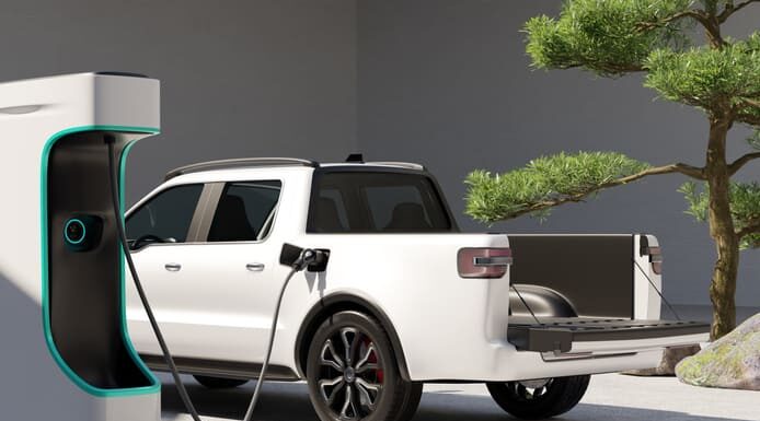 White Electric Pickup Truck connected to charging station