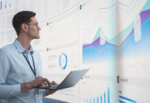 The Importance of Data Analytics in Business Travel Management Caucasian Male Business Analyst Holding Laptop Computer