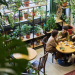 Exploring The Esthetically Diverse Landscape Of Restaurant Chairs Two intercultural friends or dates having chat in cafe while sitting by table next to young woman drinking latte and listening to their discussion