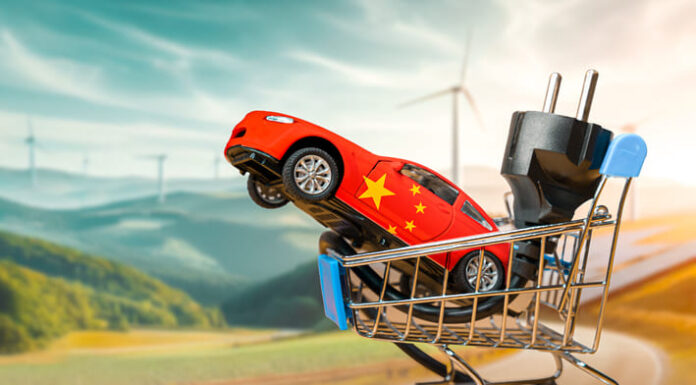 Humanoid Robots: The Next Battleground Between Tesla and China Toy car with the chinese flag and electrical plug inside a small shopping cart