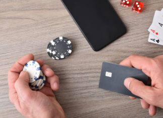 Casino game player accessing payment card to make virtual bets