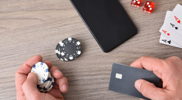 Casino game player accessing payment card to make virtual bets