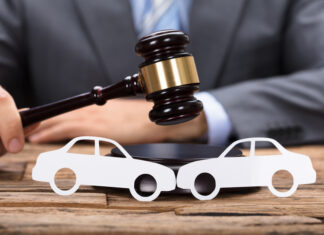 How Can a Car Accident Attorney Near Me in Charlotte Help with Your Injury Claim? Midsection of judge hitting mallet by paper cars on wooden table