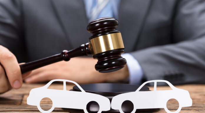 How Can a Car Accident Attorney Near Me in Charlotte Help with Your Injury Claim? Midsection of judge hitting mallet by paper cars on wooden table