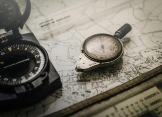 Black and Silver Compasses on Top of Map