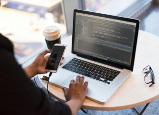 Person Holding Smartphone while using Laptop
