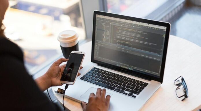 Person Holding Smartphone while using Laptop